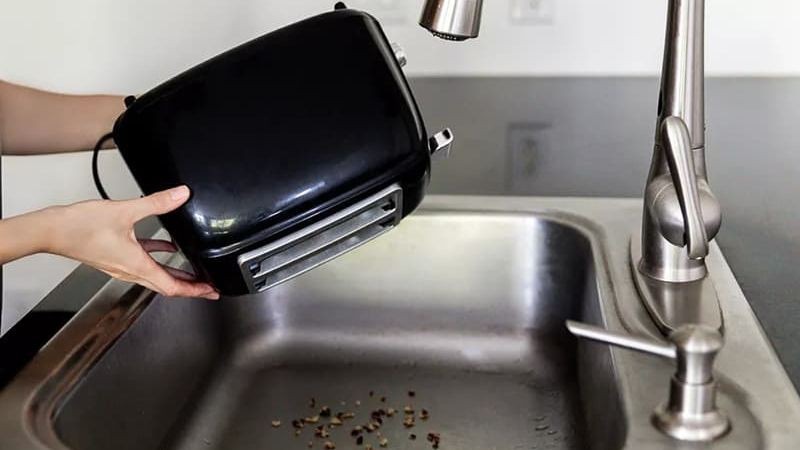 Lật ngược máy và gõ nhẹ để vụn bánh mì rơi xuống